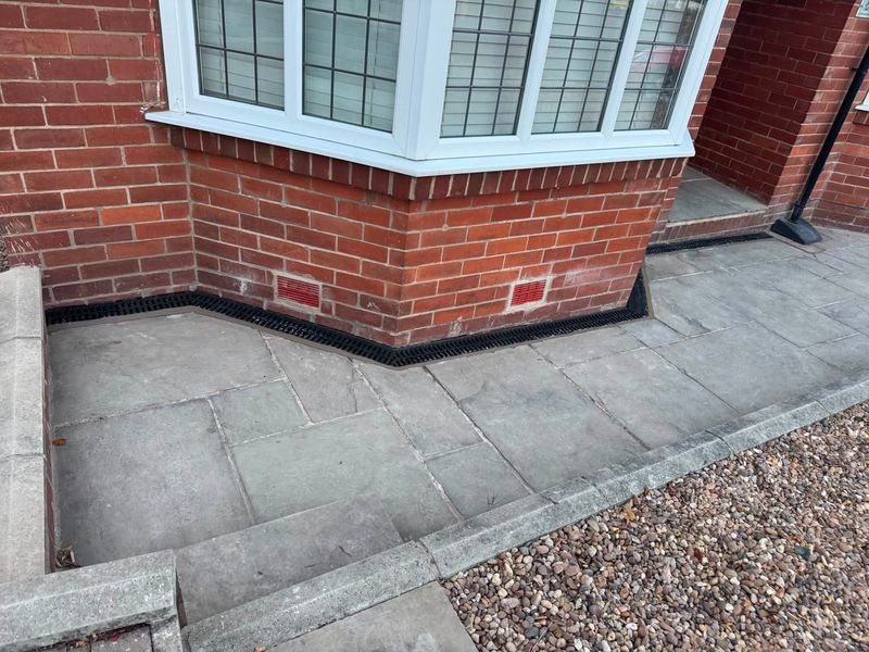 The finished drainage channel across the front of the house