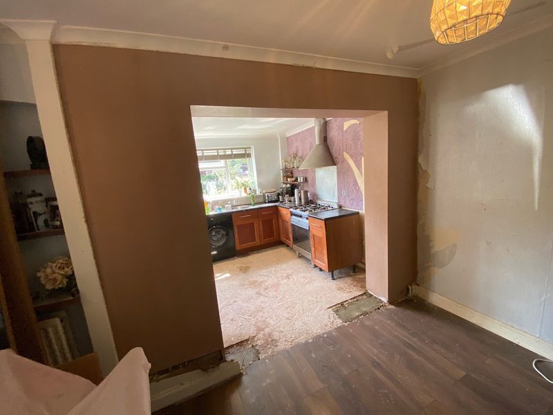 The wide new opening through to the kitchen, freshly plastered