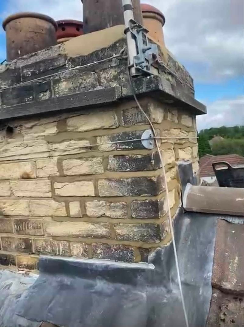 Stone chimney stack with lead flashing where it meets the roof