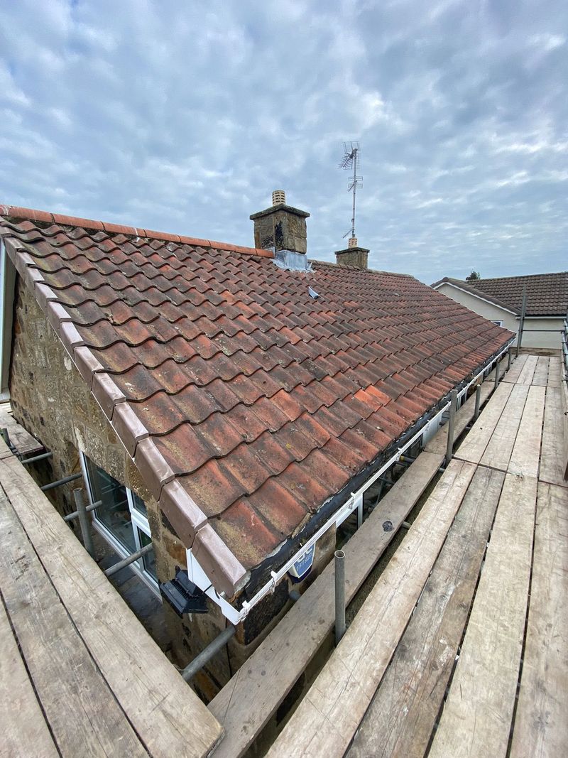 The old tiled roof and chimney from the other side of the scaffold