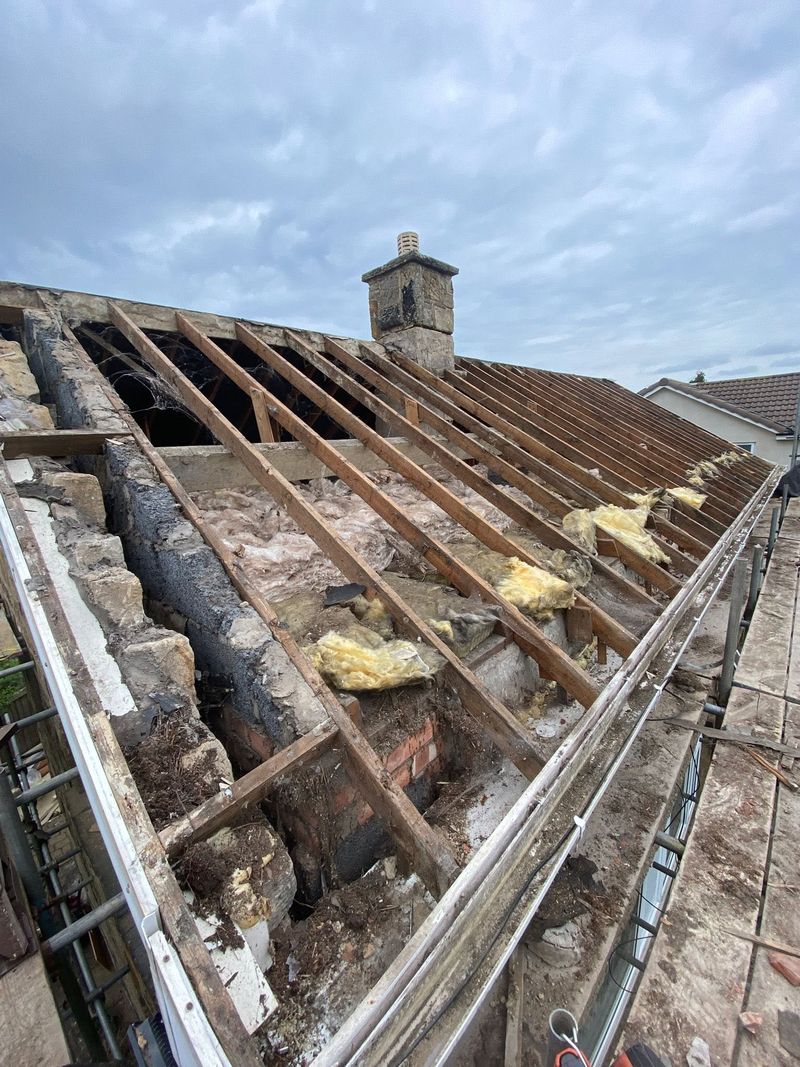 The roof stripped of tiles and battens, with the bare rafters exposed