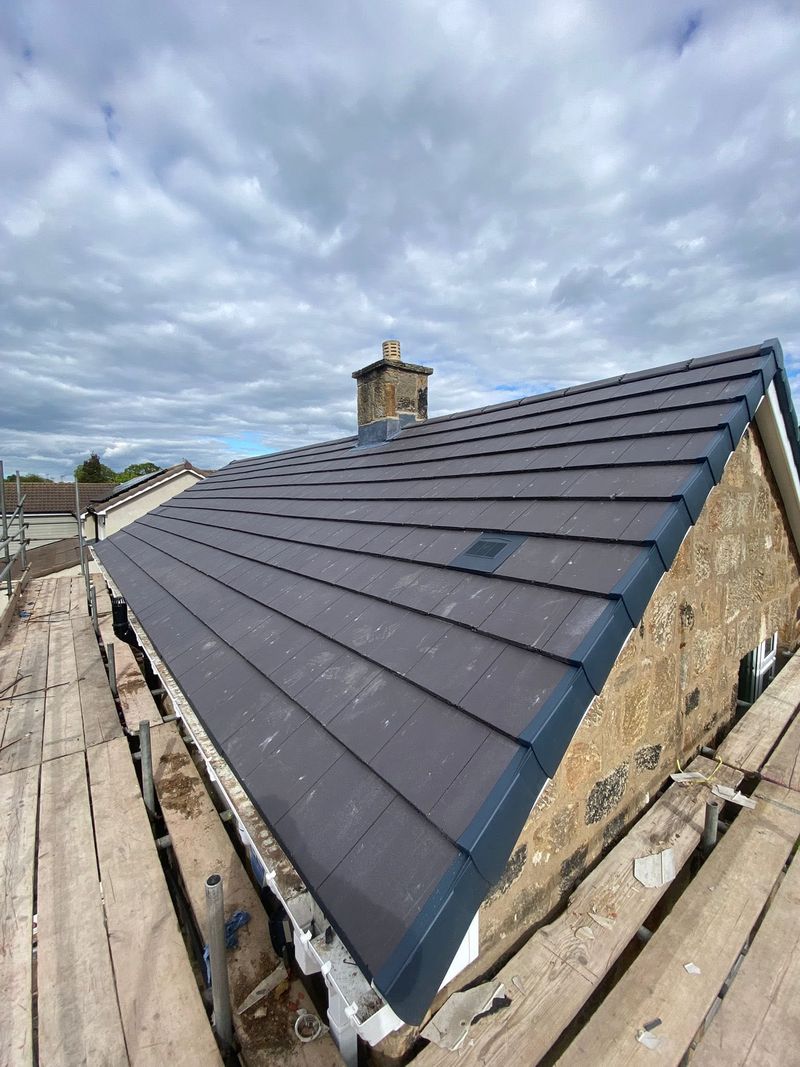 The finished grey tiled roof with the hips and ridge completed